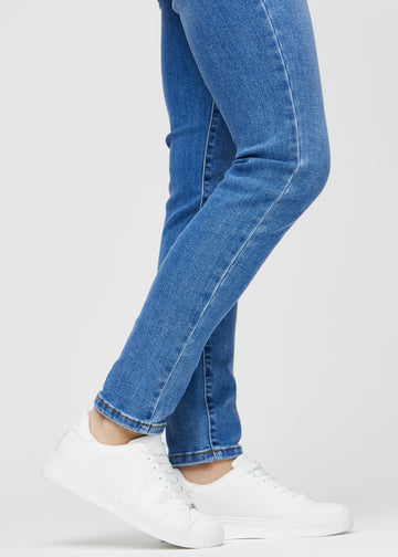Slim jeans for women in blue, color Rivers. Close-up at the ankles on a model, showing the fit at the leg openings.