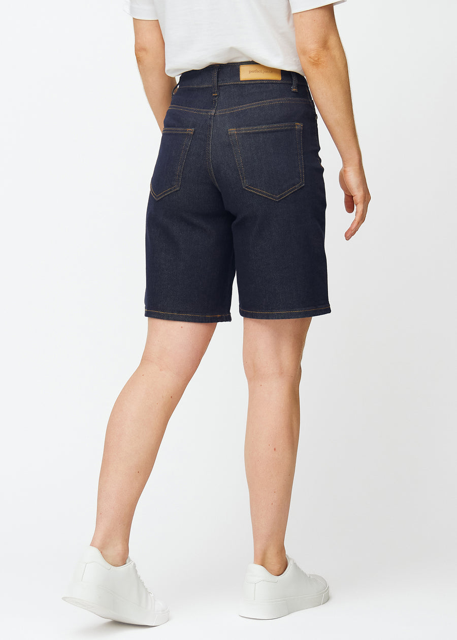 Deep dark blue denim shorts for women in the colour Midnights seen from the back, showing the length just above the knee.