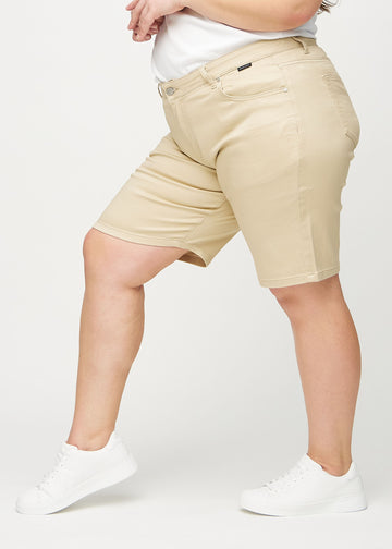 Beige regular middle shorts seen from the side on a plus-size model.