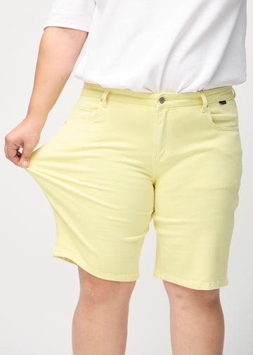 The plus-size model stretches the shorts at the thigh to show the stretch.
