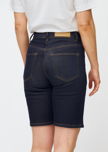 Deep dark blue denim shorts for women in the colour Midnights seen from the back in close-up to show fit and details.