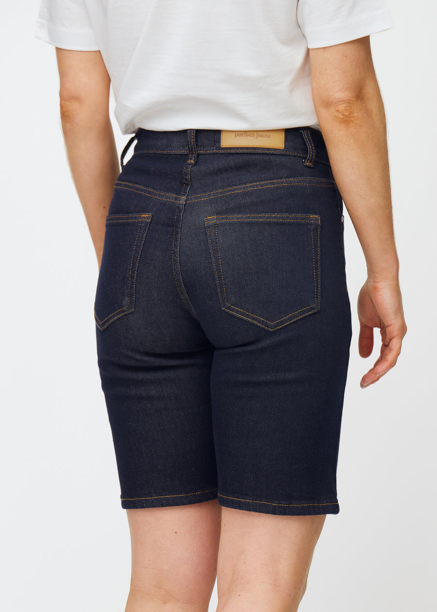 Deep dark blue denim shorts for women in the colour Midnights seen from the back in close-up to show fit and details.