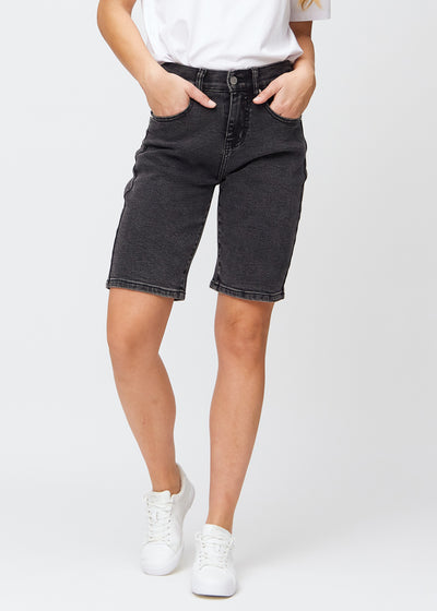 Dark grey denim regular middle shorts, model name Shadows, which fall straight down the leg and end just above the knee, seen from the front.