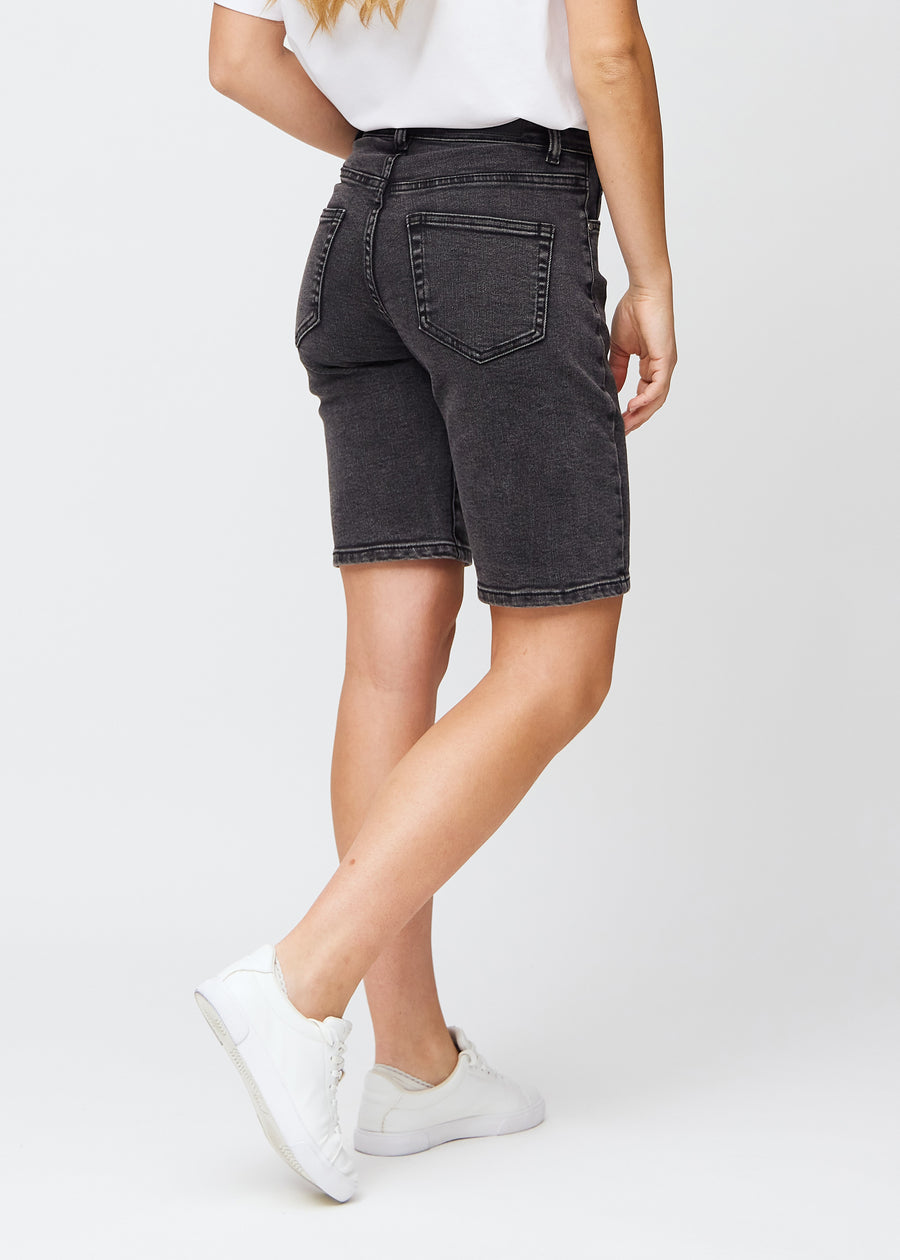 Woman in knee-length dark grey denim shorts, seen from the back