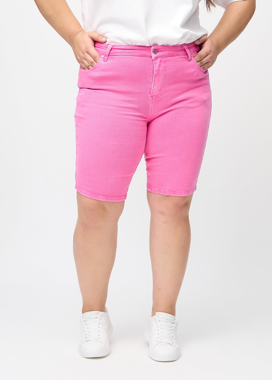 Light pink skinny middle shorts, model name Flamingos, which fit tightly around the thigh and end just above the knee on a plus-size model, seen from the front.