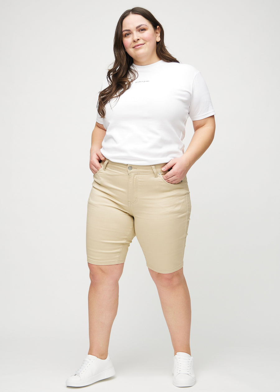 Full image of a plus-size model in beige skinny middle shorts.