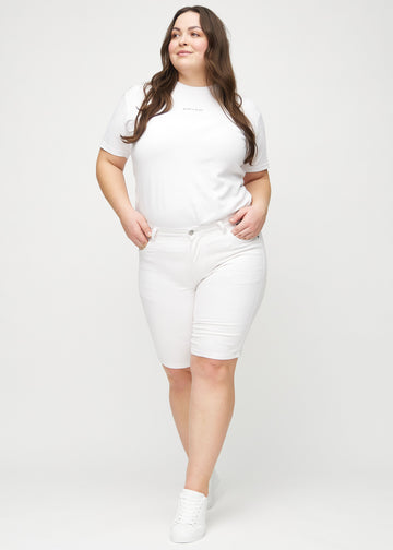 Full image of a plus-size model in white skinny middle shorts.