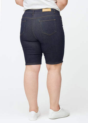 Deep dark blue denim shorts for women in the colour Midnights seen from the back on a plus-size model.