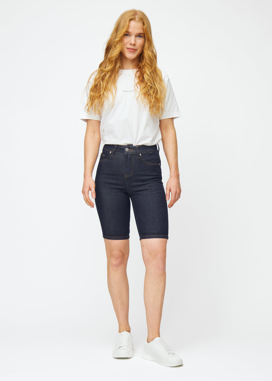 Full image of a model wearing deep dark blue denim shorts for women in the colour Midnights with a skinny fit.