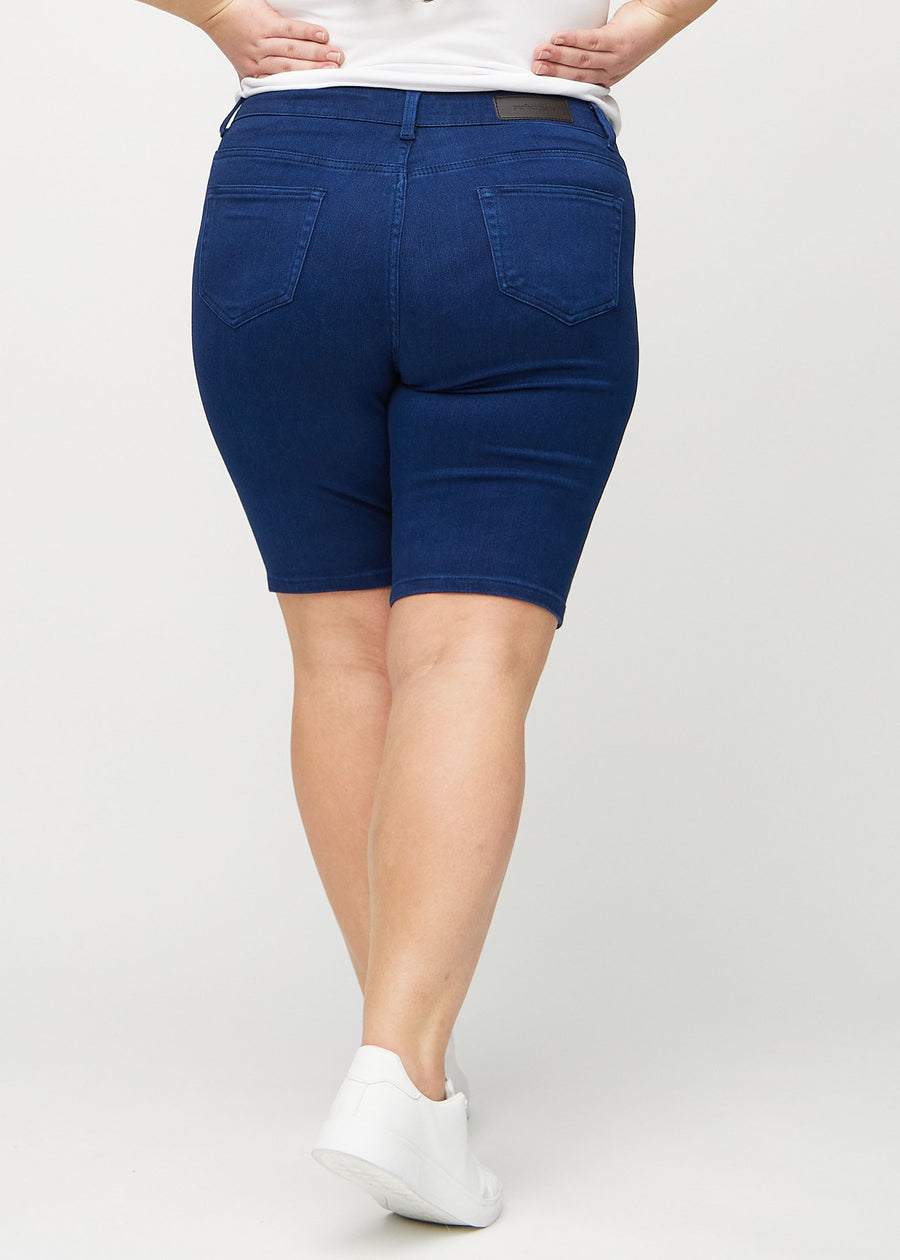 Dark blue skinny middle shorts seen from the back on a plus-size model, so the entire product can be seen.