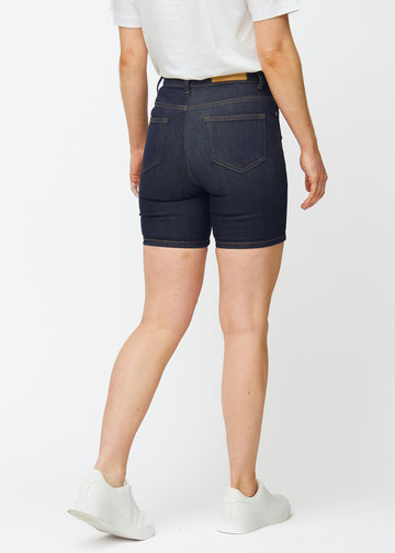 Deep dark blue denim shorts for women in the colour Midnights seen from the back, showing the close fit and the length to mid-thigh.