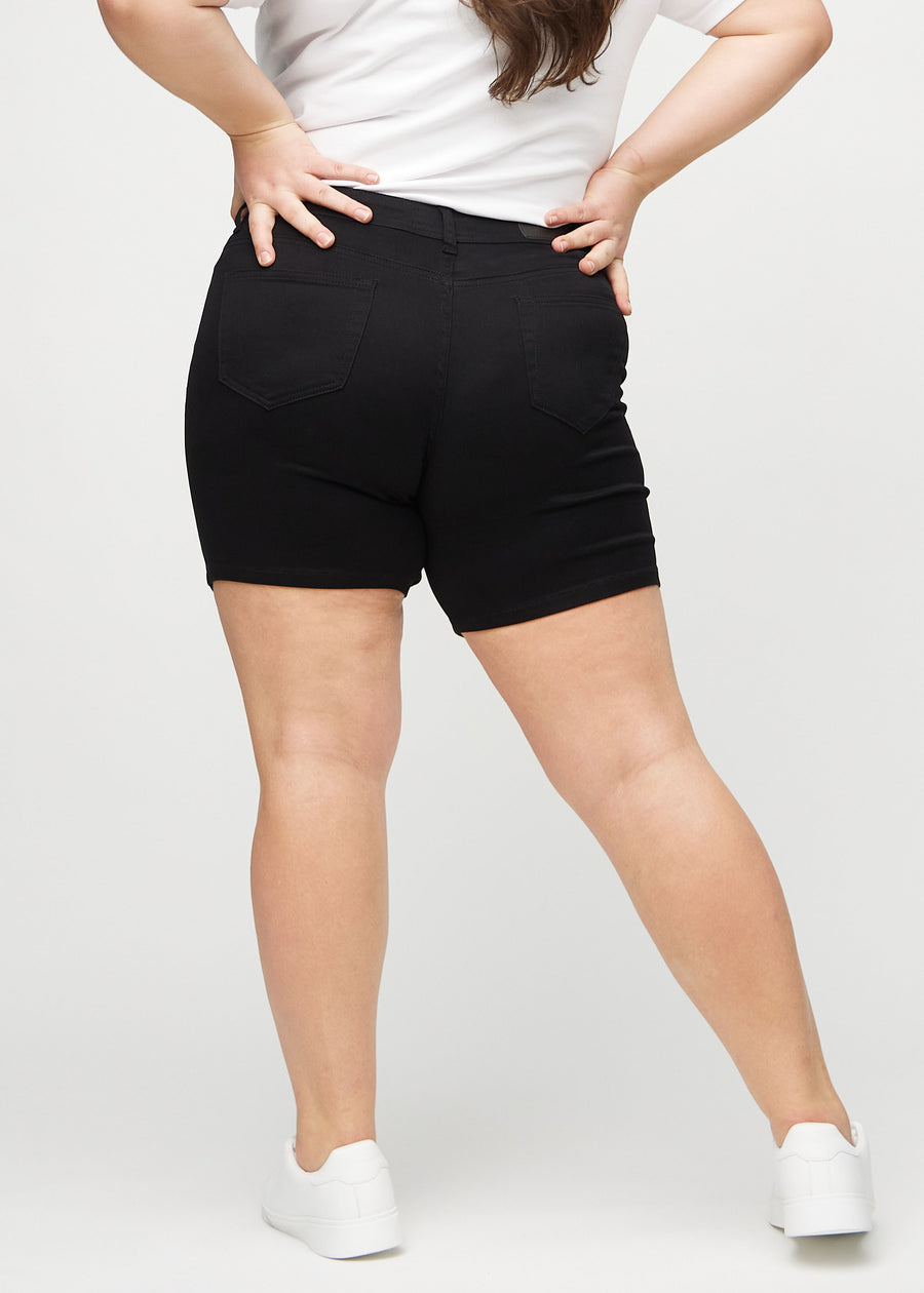 Black skinny short shorts seen from the back on a plus-size model, so the entire product can be seen.