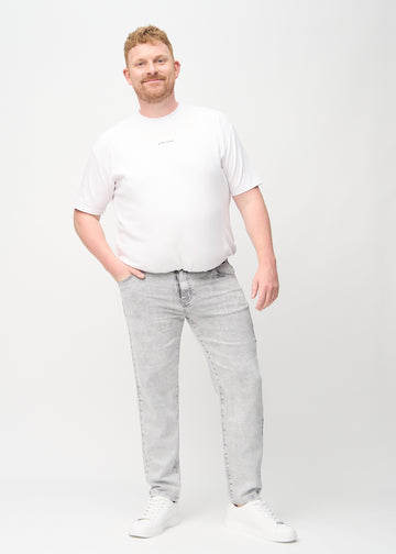 Full image of a plus-size model in light grey denim regular jeans.