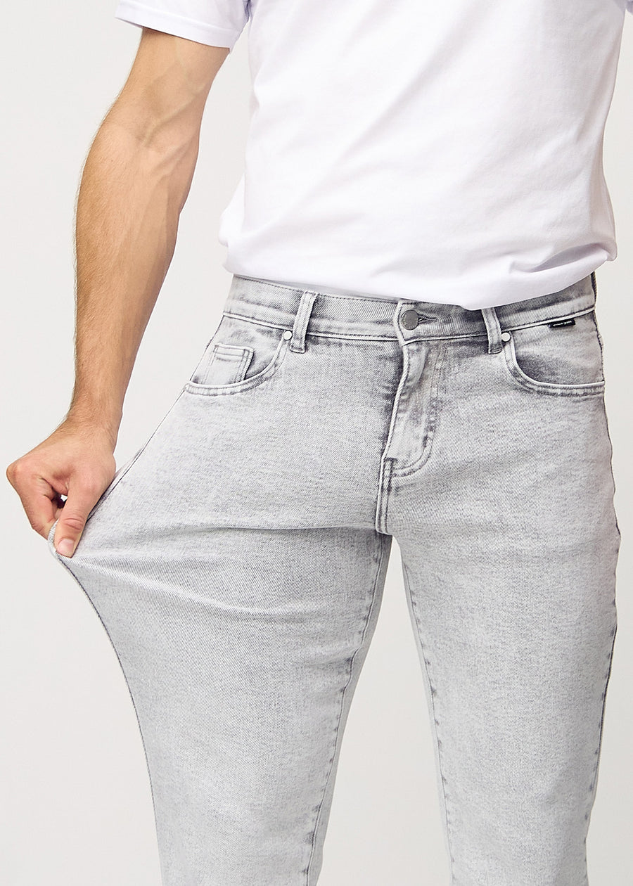 The model stretches the jeans at the thigh to show the stretch.