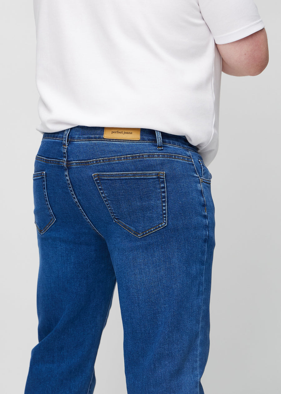 Dark blue denim regular jeans seen from the back close up on a plus-size model to show details.