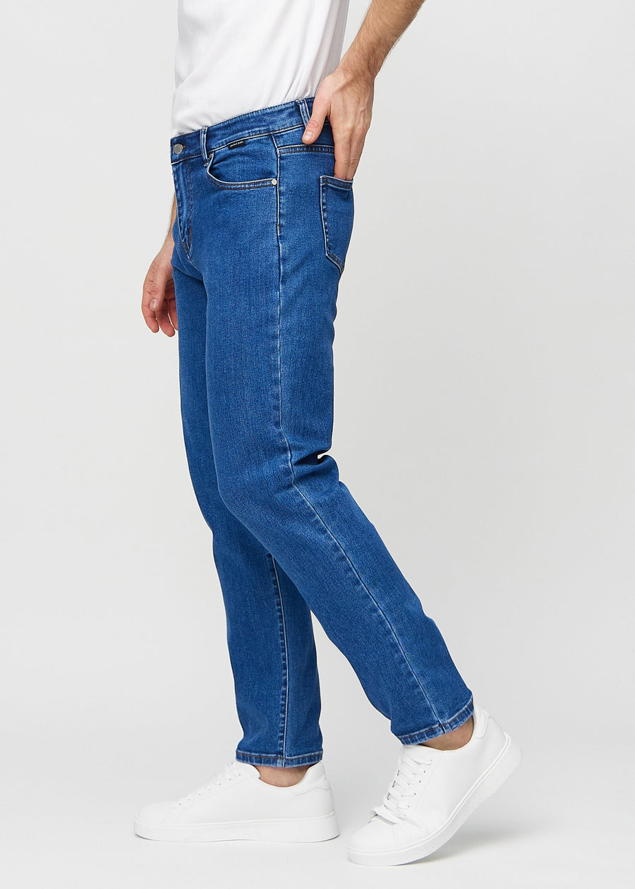 Dark blue denim regular jeans seen from the side on a model.