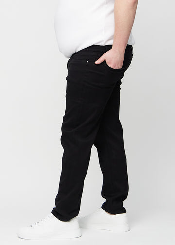 Black regular jeans seen from the side on a plus-size model.