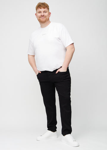 Full image of a plus-size model wearing black regular jeans.