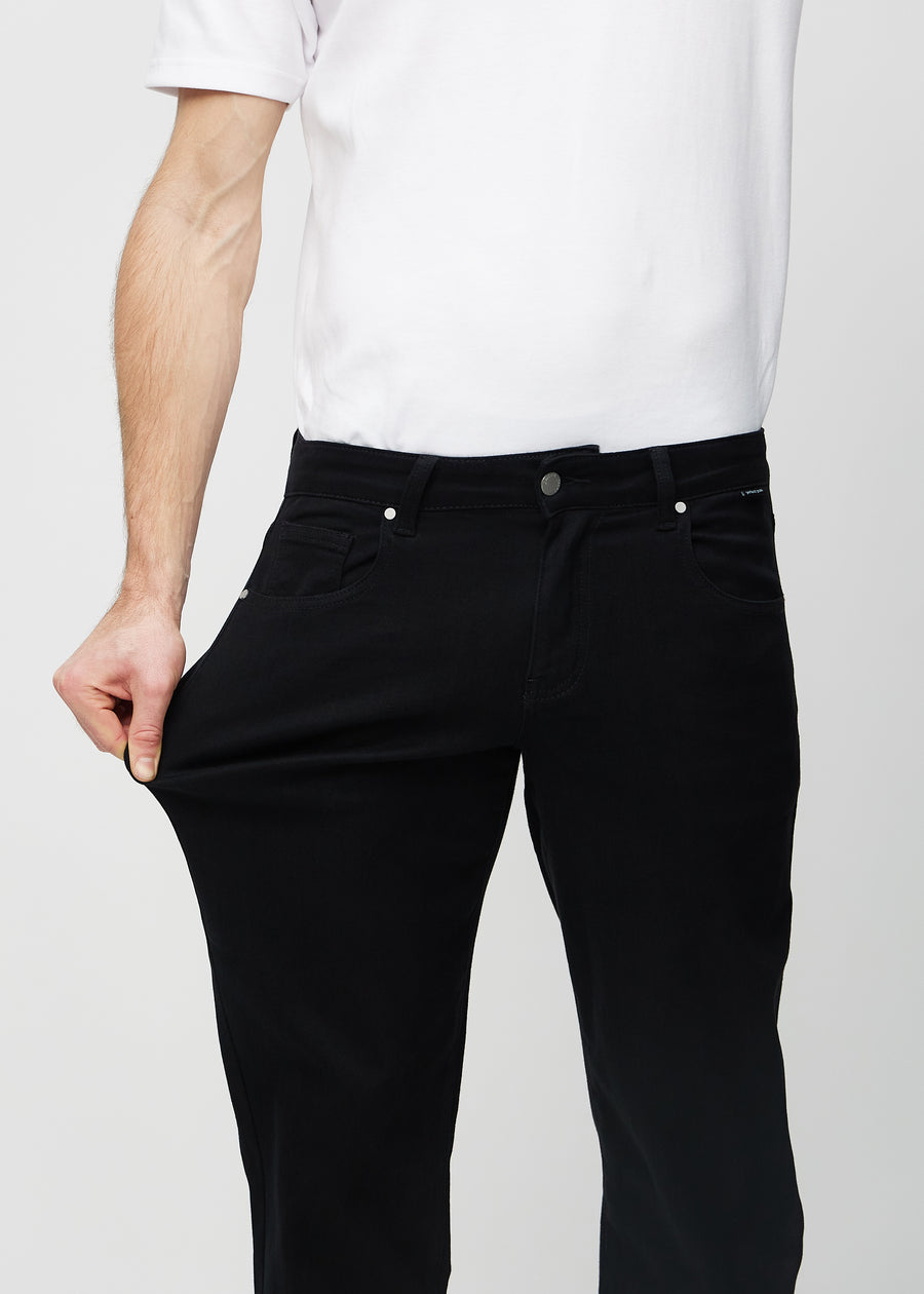 The model stretches the jeans at the thigh to show the stretch.
