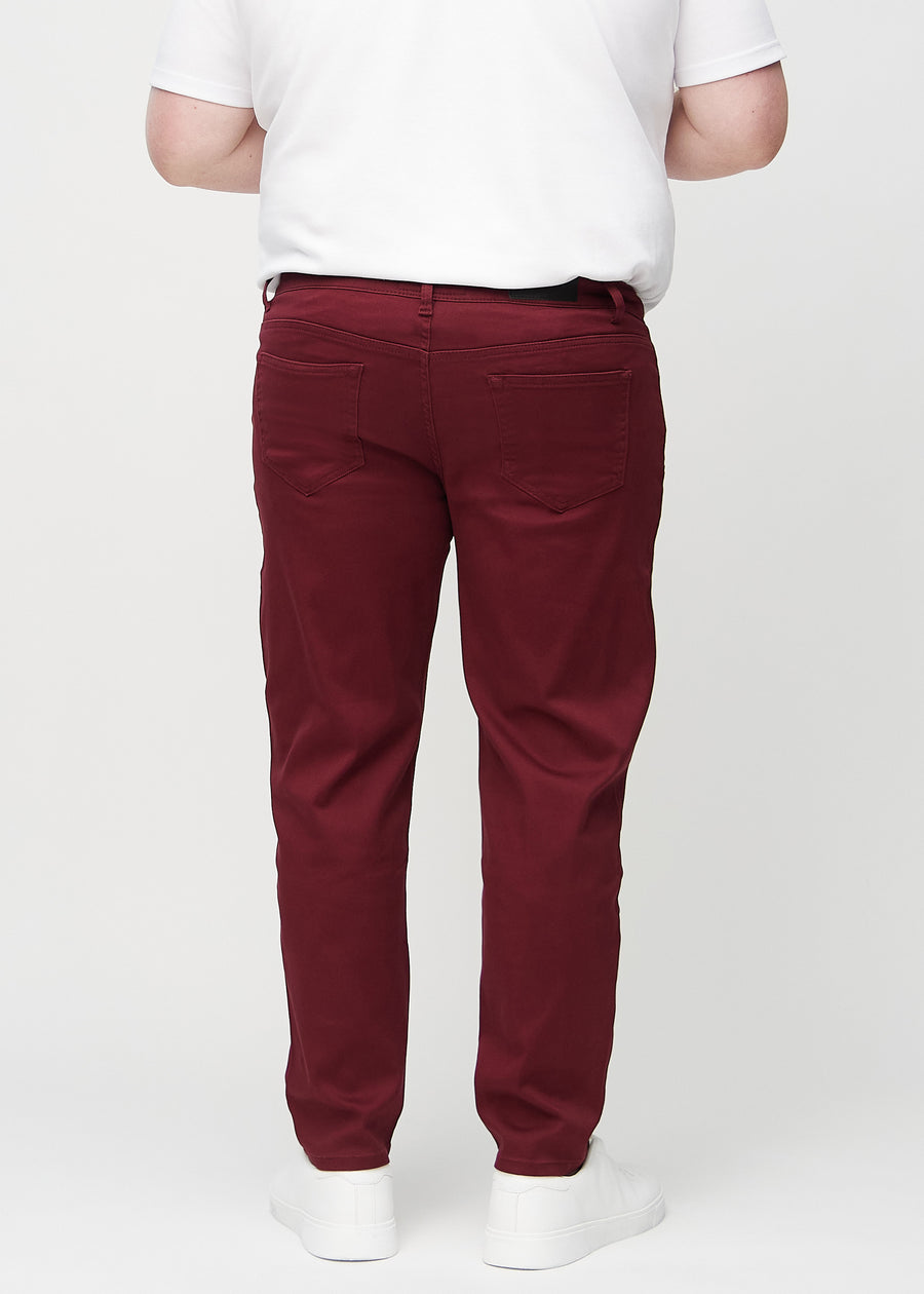 Dark red regular jeans seen from the back on a plus-size model, so the entire product can be seen.