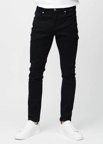 Black slim jeans, model name Ravens, fitted closely along the legs, front view.