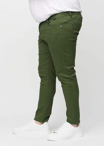 Dark green slim jeans viewed from the side on a plus-size model.