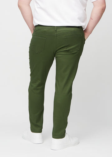 Dark green slim jeans viewed from the back on a plus-size model to show the full product.