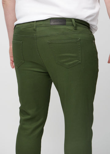 Close-up back view of dark green slim jeans on a plus-size model showing details.