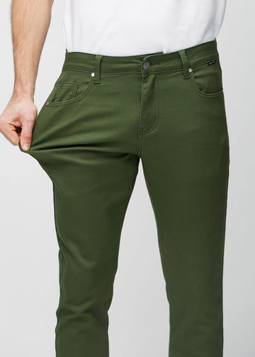 Model stretches the jeans at the thigh to show the fabric&