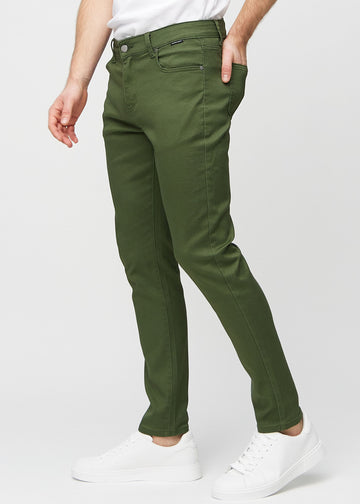 Dark green slim jeans viewed from the side on a model.