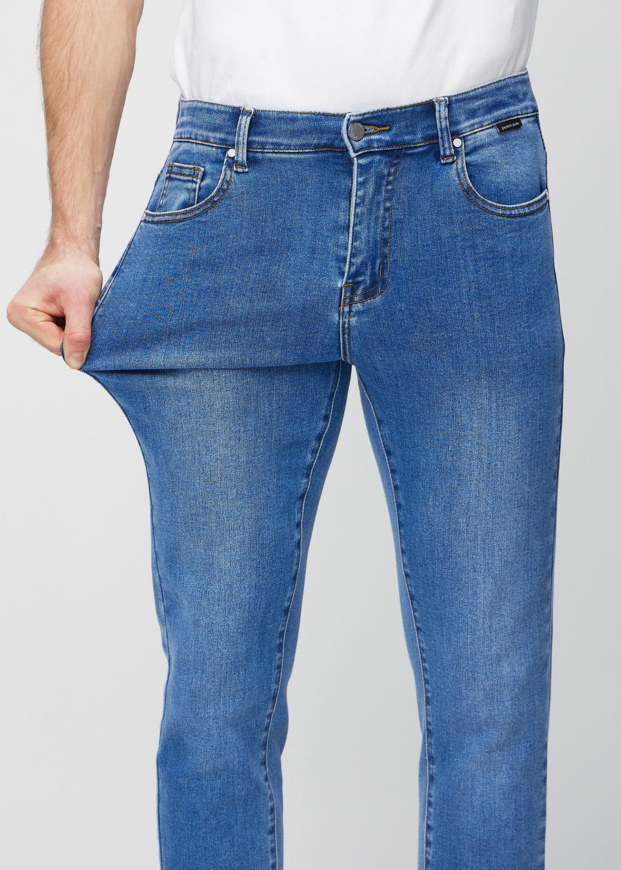 Model stretches the jeans at the thigh to show the fabric&