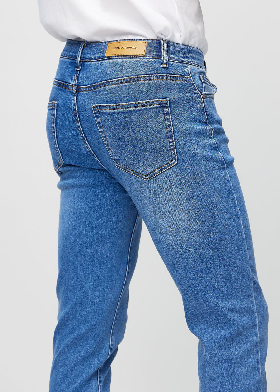 Close-up back view of blue denim slim jeans showing details.