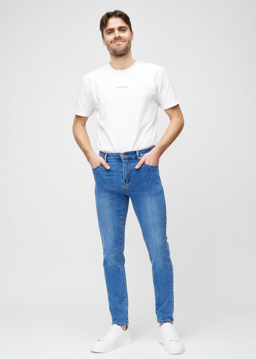 Full-length view of a model in blue denim slim jeans.