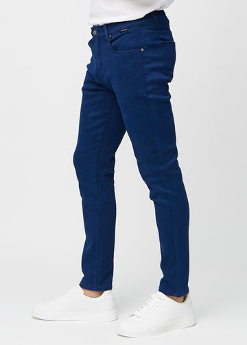Dark blue slim jeans viewed from the side on a model.