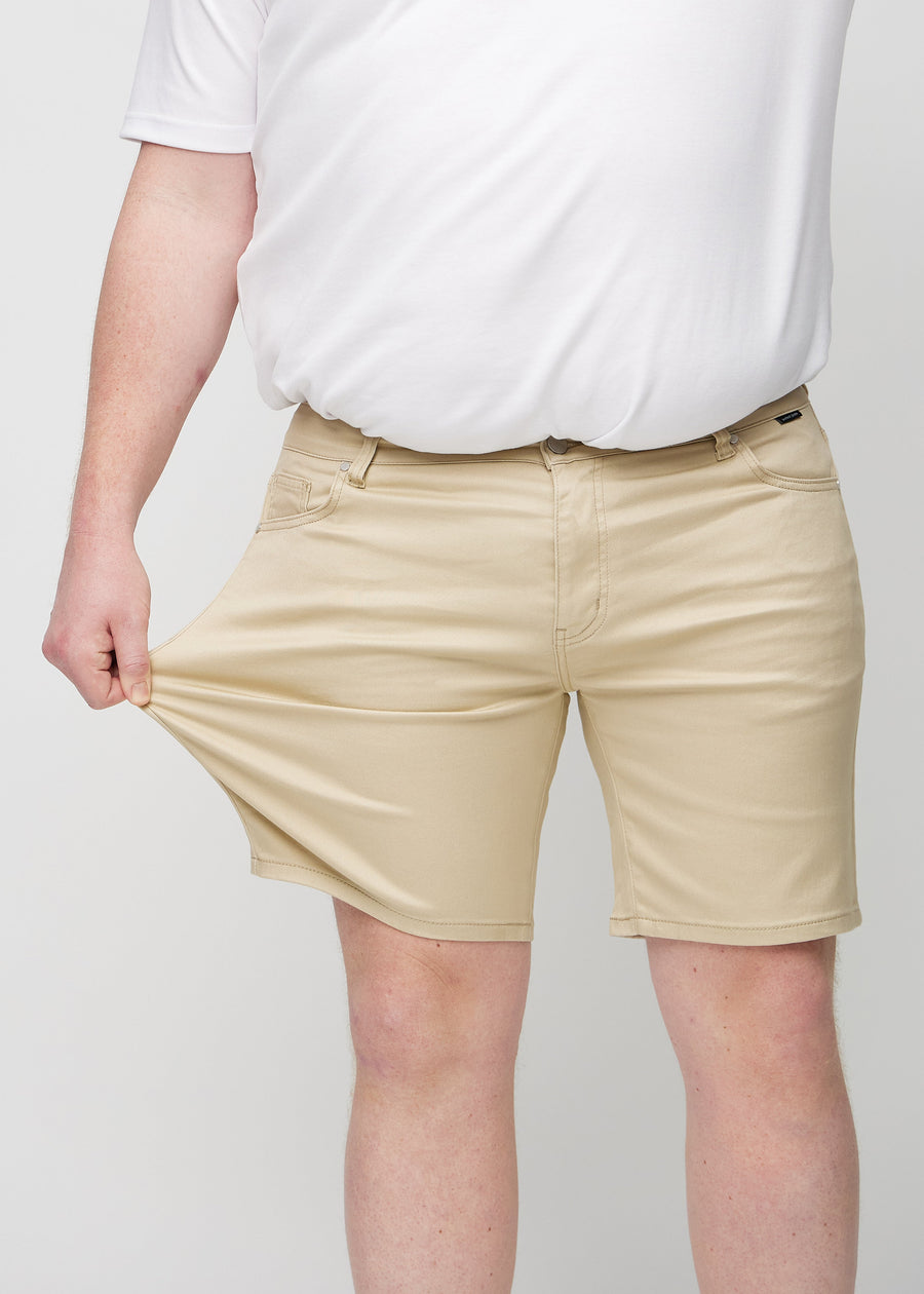 The plus-size model stretches the shorts at the thigh to show the stretch.
