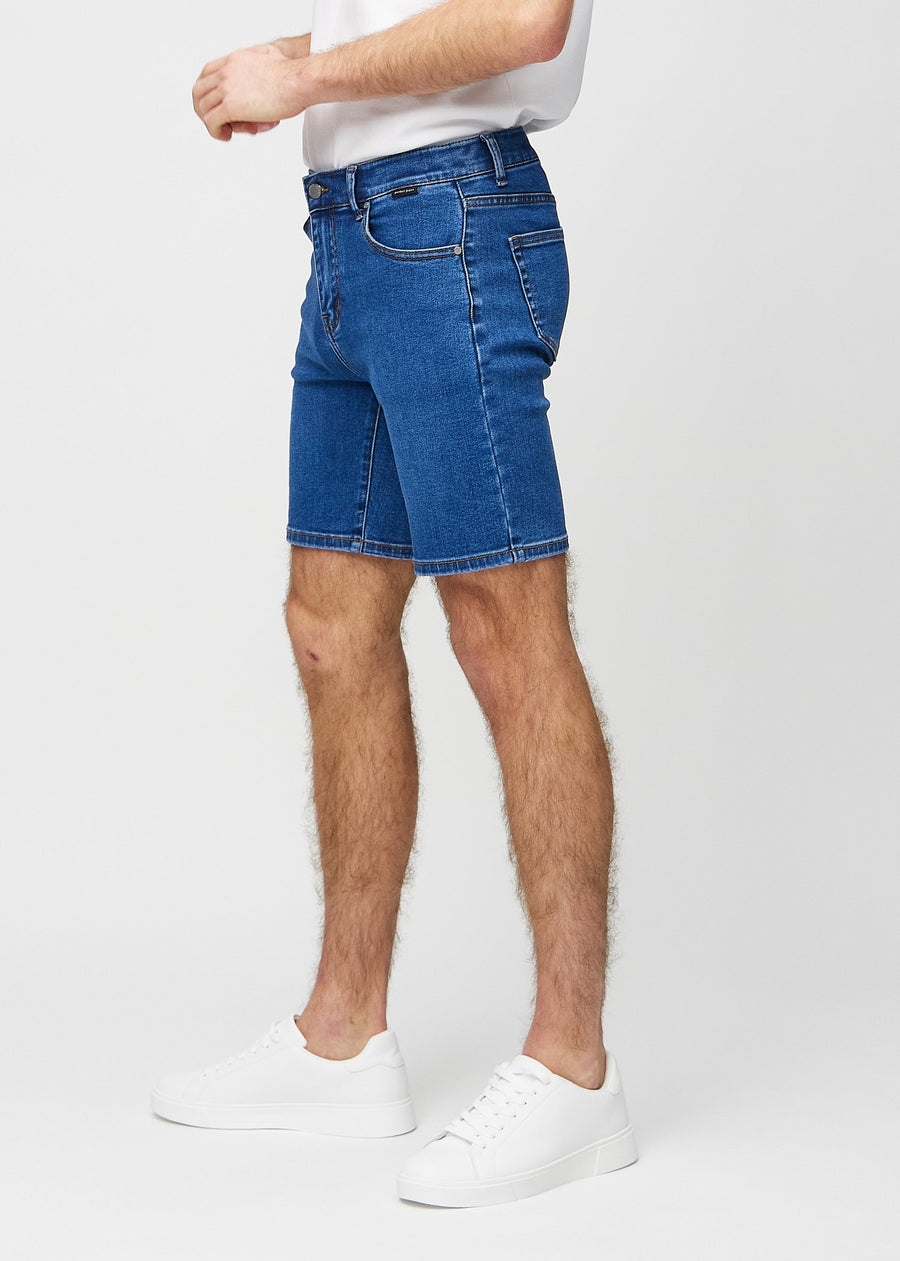Dark denim middle-slim shorts seen from the side on a model.