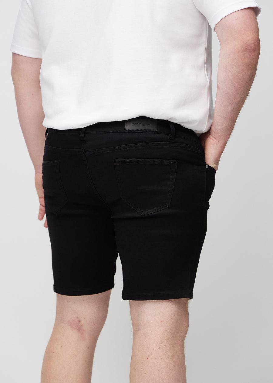 Black middle-slim shorts seen from the back close up on a plus-size model to show details.