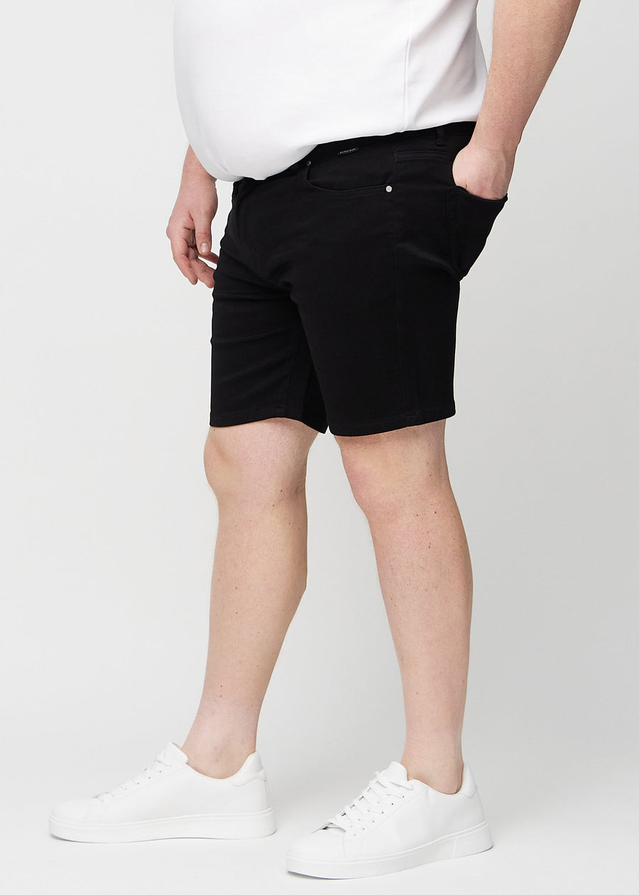Black middle-slim shorts seen from the side on a plus-size model.