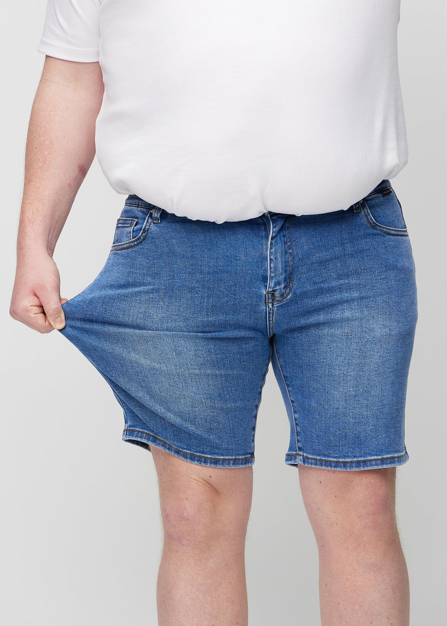 The plus-size model stretches the shorts at the thigh to show the stretch.