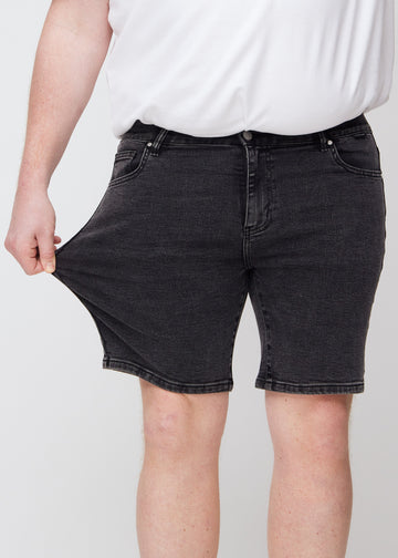 The plus-size model stretches the shorts at the thigh to show the stretch.