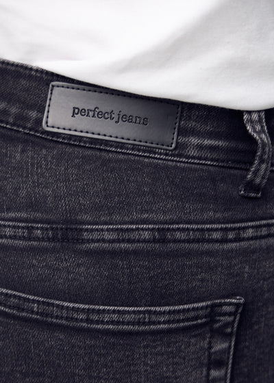 Baglommen på de mørkegrå denim – detaljebillede med fokus på logo og denimtekstur.