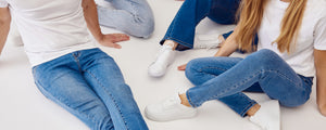 Modeller der sidder på gulvet iført blå denim jeans