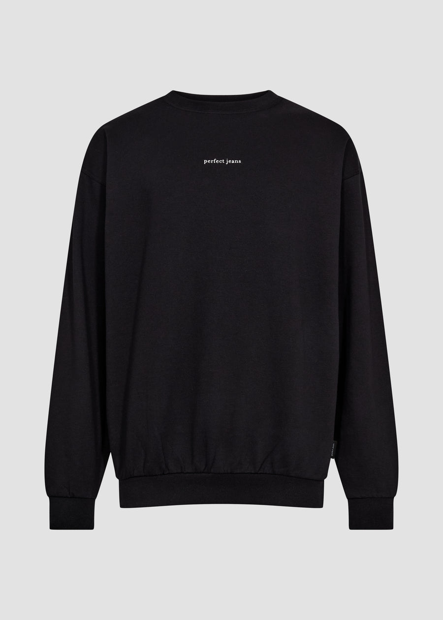Sort unisex sweatshirt fra Perfect Jeans, med hvidt logo midt på brystet, set forfra.