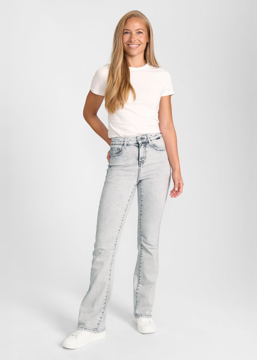 Fuldt billede af model i lysegrå denim bootcut jeans.