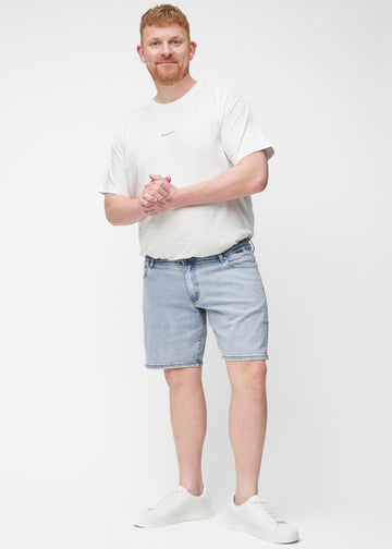 Plus-size model viser lyseblå denim shorts til mænd i farven Waves med regular pasform i bevægelse.